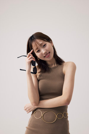 Korean Woman Wearing a Knit Dress and Holding a Sundlasの写真素材