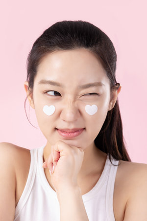 A teenage woman with a sticker on her face and a cute expression on her faceの写真素材