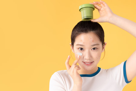 Teenage woman using skincare products to remove skin problems on her faceの写真素材