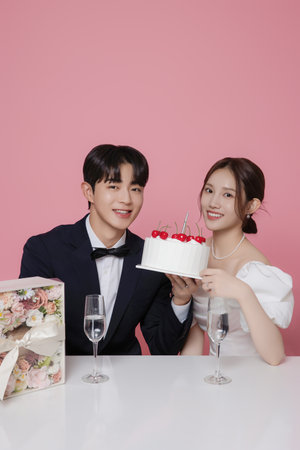 Newlywed couple smiling happily holding wedding cakeの写真素材