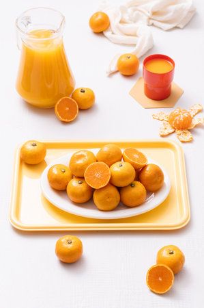 Delicious tangerines plated on a tray and a drink made from tangerinesの写真素材