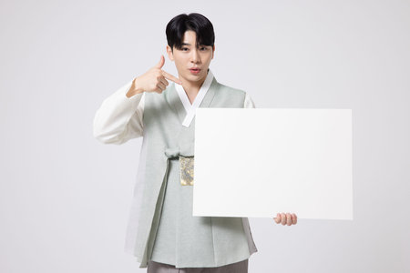 Portrait of a young man wearing hanbok and standing with copy spaceの写真素材