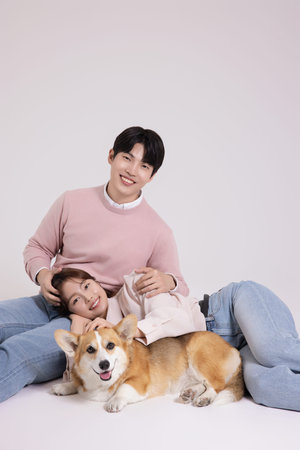Family photo of a young couple raising a cute Welsh Corgi