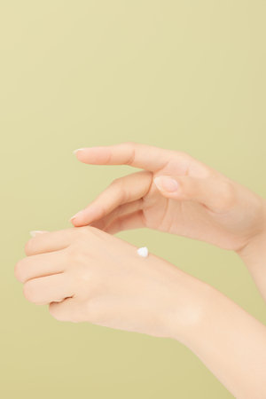 Woman's hands applying creamの写真素材