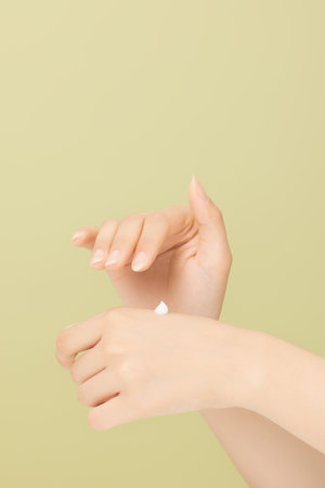 Woman's hands applying hand creamの写真素材