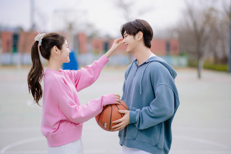 A young couple enjoying a basketball date in the parkの写真素材
