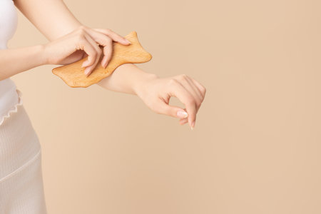 A woman massaging her arms with gua shaの写真素材