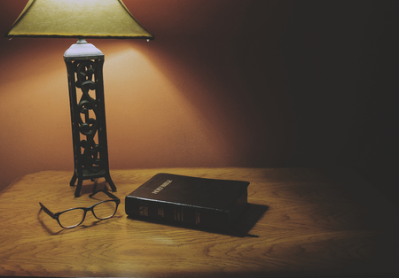 Holy Bible On Wood Table With Glasses Under Lampの写真素材