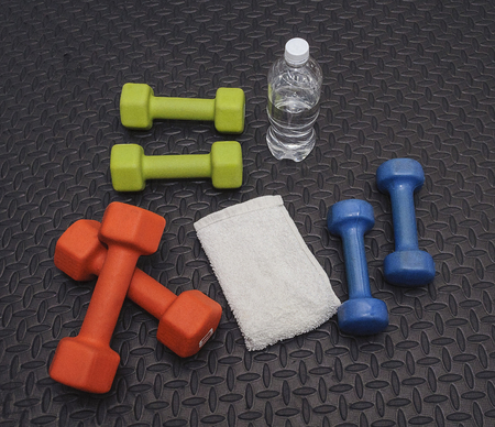 Colorful Hand Weights, Towel And Water On Workout Matの写真素材