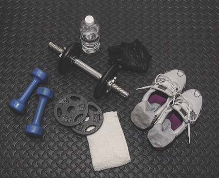 Weights, Water, Towel, Gloves And Shoes Laying On Workout Matの写真素材