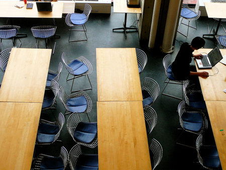 Man on laptop computer in university building, seen from aboveの写真素材