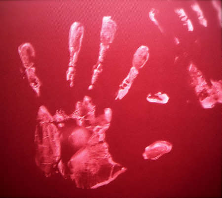 Hand Prints in White Paint on Red Backgroundの写真素材