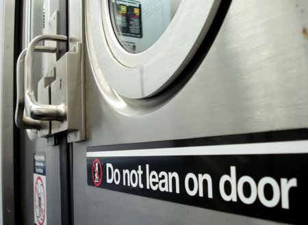 New York City Subway Train with Do Not Lean on Door Warning Sign