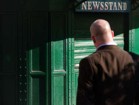 Morning Commute: Businessman Passing Newsstandの写真素材