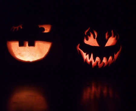 Spooky and Smiling Halloween Pumpkins Illuminated at Nightの写真素材