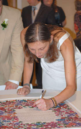 Bride Signing Traditional Ketubah During Jewish Wedding Ceremonyの写真素材