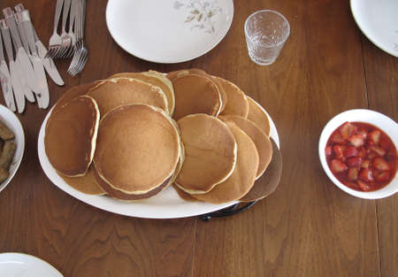 Breakfast table laid out with pancakes and strawberriesの写真素材