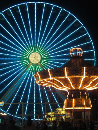 Ferris Wheel and Carousel in Amusement Park at Nightのeditorial素材