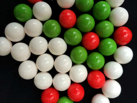 Red, Green, and White Round Christmas Holiday Candy or Gumballs Isolated over Black Backgroundの写真素材