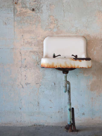 Rust covered ceramic old sink in abandoned bathroomの写真素材