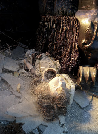 Scary Halloween Tableau: Cracked shattered antique ceramic doll covered with cobwebsの写真素材