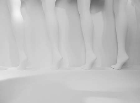 Row of mannequin legs against white background in store display windowの写真素材