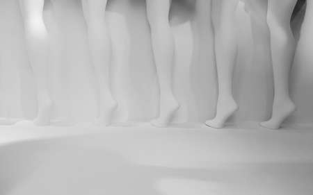 Row of mannequin legs against white background in store display windowの写真素材