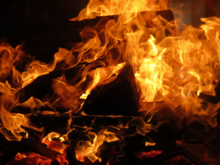 Detail of burning logs, fire, and flames in fireplace or campfire
