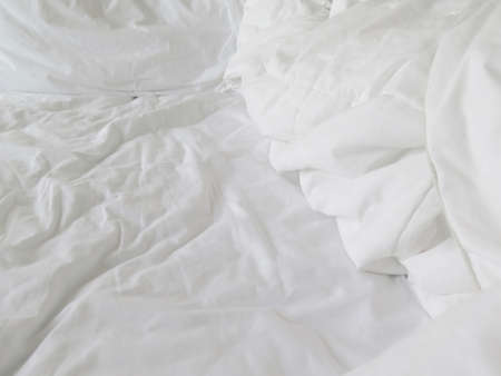 Detail of bed with set of white morning beddingの写真素材