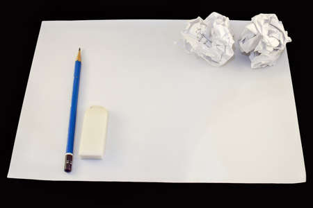 Drawing paper with pencil, rubber and two crumpled paper balls.の写真素材