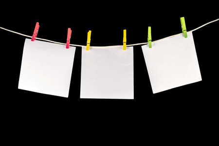 Clothes peg holding message papers with the black background, vaccation note or holiday noteの写真素材
