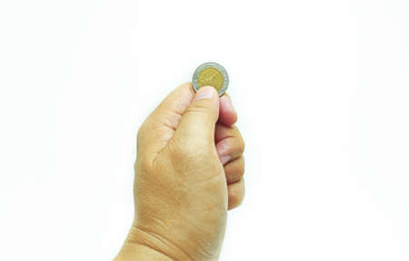 Isolated hand holding up the coin with thumb and index fingers on white background.の写真素材