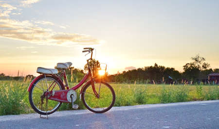 Relaxing time to cycling and park the bicycle on the road during sunset.の写真素材