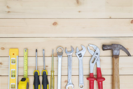 Tools set on wood table. screwdriver, tape measure, hammer and wrench.Technical tooling concept.