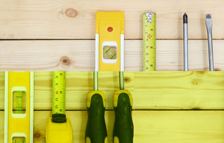 Tools set on wood table. screwdriver, tape measure and leveling. Technical tooling concept.