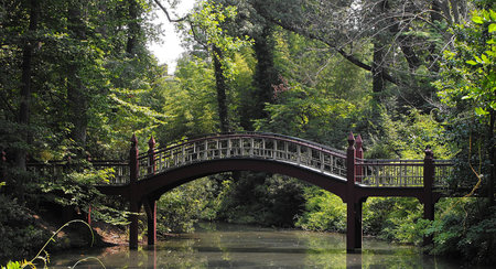 Arched bridge over a still streamの写真素材
