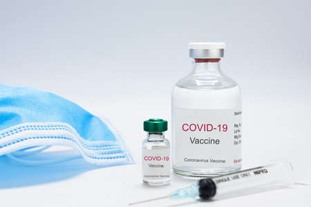 Bottle with vaccine against covid-19 and syringe on white background for background usage. Vial with coronavirus vaccine developed for protection against COVID-19. Healthcare and medical concept.の写真素材