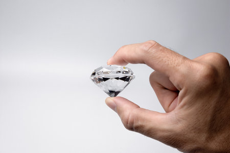 Close-up of the hand with large size round cut diamond on white background.の写真素材
