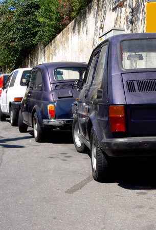 Three generation of tiny italian cars parked on the same street in Sicily Italyの写真素材