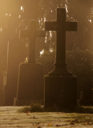 Tombstones with crosses covered in  the morning frost and mistの写真素材