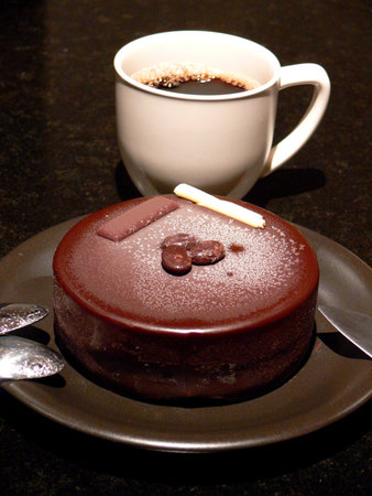 A cup of coffee and icecream cake for dessert