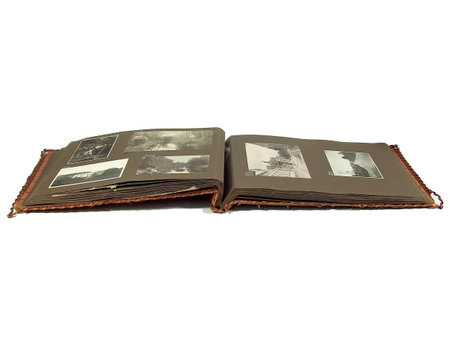 An old worn photo album laying open on whiteの写真素材