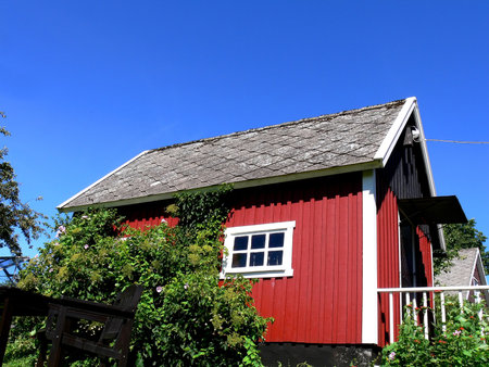 A small red classic wooden house on the countryside in soutern Swedenの写真素材