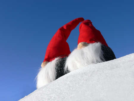 Two bearded santas on a snowy slope under a bright blue skyの写真素材