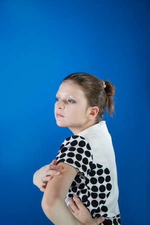 beautiful girl in the blue background coated with face makeupの写真素材
