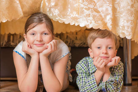 Portrait a fullface of the smil girl and the boy s at a table with bananasの写真素材