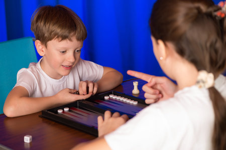boy and girl playing in the ancient oriental game called Backgammon