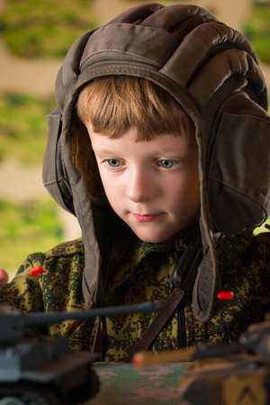 Boy playing toy. Radio-controlled toy military tank. Camouflage protective coloration .の写真素材