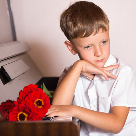 boy student pianist bestowed with a bouquet of red flowers from fans and viewers