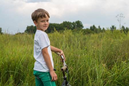 Boy riding a bike outdoors in the grass on a sunny dayの写真素材